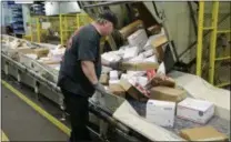  ?? NATI HARNIK — THE ASSOCIATED PRESS FILE ?? In this file photo, Steve Robino arranges packages on a conveyor belt at the main post office in Omaha, Neb. The shipment of several pipe bombs to CNN and several prominent Democrats raises fresh questions about mail safety and what measures the U.S. Postal Service and private delivery services take to prevent explosives and other illegal substances from entering into the mail.