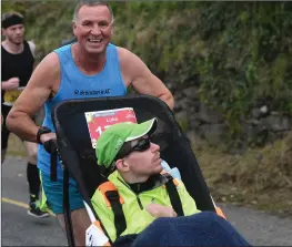  ??  ?? Half Marathon wheelchair athlete Luke Graham from Dingle being pushed by his friend Pat Sheehy from Causeway. Pic: Dominick Walsh