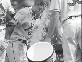  ?? Associated Press ?? Take a shower: St. Louis Cardinals' Kolten Wong, left, is congratula­ted by teammates after hitting a walk-off home run during the ninth inning of a baseball game against the Pittsburgh Pirates Saturday in St. Louis. The Cardinals won 3-2.