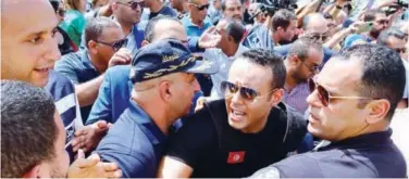  ?? Reuters ?? ±
Police members push back supporters of Ennahda protesting in support of the party leaders in Tunis on Monday.