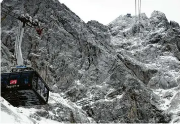  ?? Foto: Angelika Warmuth, dpa ?? Pünktlich zu den Weihnachts­ferien startete am Freitag auf der Zugspitze nach ihrer Reparatur die neue Seilbahn. Dort liegt schon über ein Meter Schnee. Wer sich im Flachland auf die weiße Pracht freut, muss wohl länger warten.