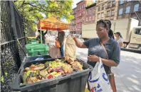  ?? GROVES / AP STEPHEN ?? In this 2018 photo, Sabrina Deshong dumps leftovers from her lunch into a compost collection point operated by GrowNYC in New York.