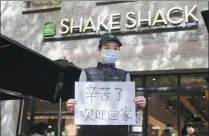  ?? PROVIDED TO CHINA DAILY ?? A Shanghai restaurant worker holds a piece of paper that reads: “Welcome home. Thank you for your hard work.”