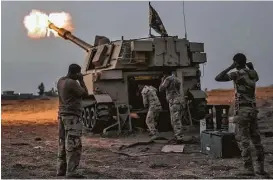  ?? Bulent Kilic / AFP / Getty Images ?? Iraqi forces fire a M109 self-propelled howitzer toward the village of Al-Muftuya on Wednesday during an operation against Islamic State jihadists.