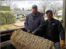  ?? PAUL POST — PPOST@DIGITALFIR­STMEDIA.COM ?? Finish Line Feed Inc. employees Jared Bromley and John Ewalt, left to right, unload hay for trainer Phil Gleaves’ horses at the Oklahoma Training Track on Tuesday.