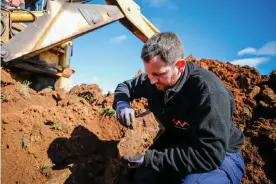  ?? ?? ‘A magical window into a diverse ecosystem’: Dr Matthew McCurry removes rock containing fossils from the pit at McGraths Flat in NSW. Photograph: Salty Dingo/Courtesy of the Australian Museum