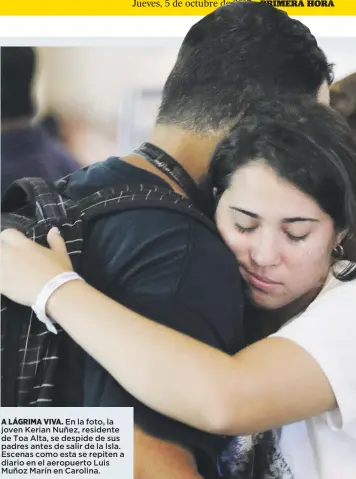  ??  ?? A LÁGRIMA VIVA. En la foto, la joven Kerian Nuñez, residente de Toa Alta, se despide de sus padres antes de salir de la Isla. Escenas como esta se repiten a diario en el aeropuerto Luis Muñoz Marín en Carolina.