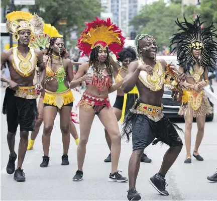  ?? ALLEN MCINNIS ?? A sudden cloudburst didn’t deter these dancers as they took part in the annual Carifiesta parade in Montreal on Saturday.