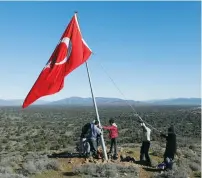  ?? (Osman Orsal/Reuters) ?? VILLAGERS FIX a broken pole bearing the Turkish flag in Sugedigi, in Turkey’s Hatay province, on the Syrian border yesterday.