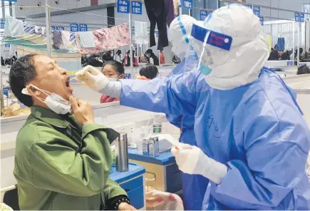  ?? Photo / AP ?? A Shanghai resident is tested in a temporary Covid quarantine centre.