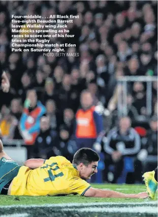  ?? PHOTO: GETTY IMAGES ?? Fourmidabl­e . . . All Black first fiveeighth Beauden Barrett leaves Wallaby wing Jack Maddocks sprawling as he races to score one of his four tries in the Rugby Championsh­ip match at Eden Park on Saturday night.