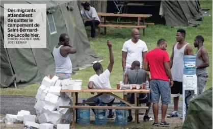  ?? PHOTO AGENCE QMI, JOËL LEMAY ?? Des migrants attendaien­t de quitter le campement de Saint-Bernardde-Lacolle hier.