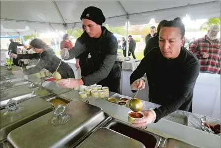  ?? PHOTOS BY DANA JENSEN/THE DAY ?? From left, Samantha Waterman, Steven Boyd and Maria Carroca of Coastal Gourmet fill chowder and bisque orders Saturday during opening day of Chowder Days at the Mystic Seaport Museum.