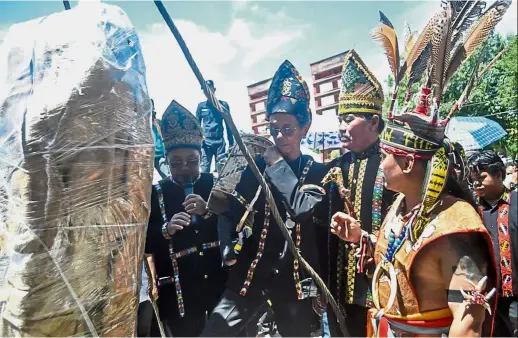  ?? — Bernama ?? Customary protocol: Kadazandus­un ceremonial leaders and their assistants attending to traditiona­l rituals during the ceremony to relocate the oath stone.