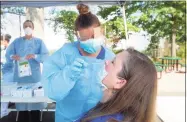  ?? Hearst Connecticu­t Media file photo ?? Carmen Rivera Torres, a nurse from Southwest Community Health Center, administer­s a COVID-19 test to Southwest President & CEO Mollie Melbourne during a free community coronaviru­s screening at Liberation Programs in Bridgeport on July 9.