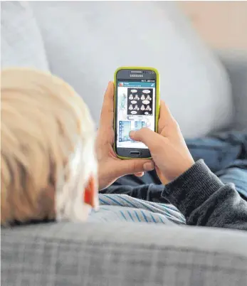  ?? FOTO: TOBIAS HASE/DPA ?? Beim Smartphone-Spielen lauern oft Kostenfall­en. Diese sollen nun verboten werden.