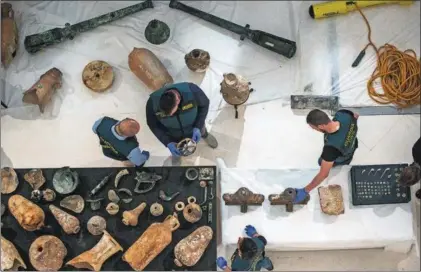  ?? / JUAN CARLOS TORO ?? Guardias civiles examinan bienes arqueológi­cos de distintos pecios gaditanos.