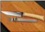  ?? RICHARD DREW — THE ASSOCIATED PRESS ?? An Opinel Cheese Knife and Fork Set on a JK Adams Cherry Cheese Server in New York. It is a compact set of an interlocki­ng fork and cheese knife made from stainless steel and a blond beech-wood handle.