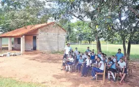  ??  ?? Niños y niñas dando clases bajo los árboles, una práctica que persiste en nuestro país debido a la precarieda­d en educación.