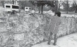  ?? ADRIAN SAINZ AP ?? A mourner places flowers on the wall of Graceland, where Lisa Marie Presley will be buried. Her father, Elvis, and son, Benjamin Keough, are also interred at the Memphis, Tenn., estate.