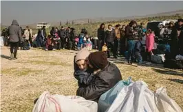  ?? NICOLE TUNG/THE NEW YORK TIMES ?? People wait to return to Syria from Turkey on Wednesday at the Cilvegozu border crossing after Syrian border officials announced a Turkish policy change.