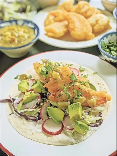  ?? Gretchen McKay / TNS ?? Beer-battered shrimp are stuffed into a flour tortilla with shredded cabbage, lime crema, avocado and salsa verde for a Lenten taco.