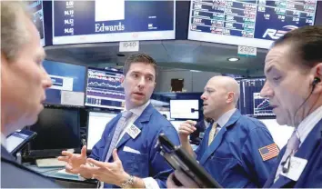  ?? — Reuters ?? Traders work on the floor of the New York Stock Exchange.