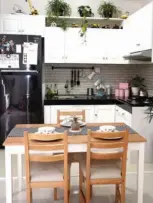  ??  ?? CANTIK DAN TRICKY: Dominasi warna putih juga bisa dilihat dari tangga berlapis parket (foto kiri) dan dapur (atas). Keramik di dinding dapur dan granit pada table top adalah cara menyiasati agar area itu mudah dibersihka­n. MIFTAHUL HAYAT/JAWA POS