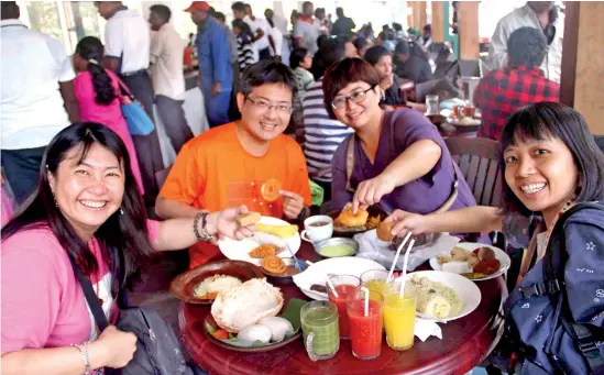  ??  ?? Chinese tourists enjoying a local meal at a restaurant.