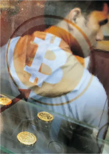  ?? KIN CHEUNG / THE ASSOCIATED PRESS ?? A man uses a Bitcoin ATM in Hong Kong on Friday. The price of Bitcoin itself, as reported by Coindesk.com, surged Monday, climbing to surpass US$17,000.