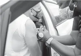  ?? MIKE STOCKER/SOUTH FLORIDA SUN SENTINEL ?? Juan Audisio receives a COVID-19 vaccine in his car at the Jessie Trice Community Health Center in Miami on April 30.