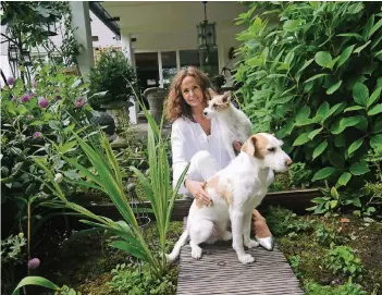  ?? RP-FOTO: GOLDLÜCKE ?? Mit den Mischlings­hunden Fritz und Lucy hält sich die Maklerin Suzanne Quante gern in ihrem Garten in Büderich auf. Dort leben aber auch noch ein Hahn, 14 Hühner und tausende von Bienen.