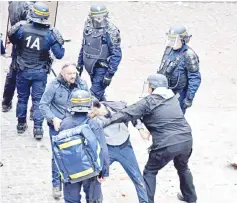  ??  ?? File photo shows Benalla (centre), wearing a police visor, next to Crase (centre, left) as they drag away a demonstrat­or during May 1 protests in Paris. — AFP photo