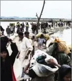  ?? FRED DUFOUR/AFP ?? Rohingya refugees walk toward refugee camps after crossing the border from Myanmar at the Bangladesh­i shores of the Naf River in Teknaf yesterday.