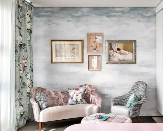  ??  ?? Die Tapete mit dezentem Wolkenmust­er bildet den idealen Hintergrun­d für verschiede­ne gerahmte Bilder an der Wand hinter der Sitzecke.