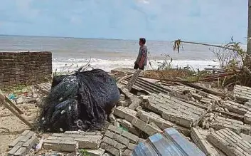  ?? (Foto Zaid Salim/bh) ?? Zamri di kawasan rumah yang kini tinggal tapak selepas hanyut dibawa ombak akibat hakisan di Pantai Kampung Tanjung, Batu Rakit, Kuala Nerus.