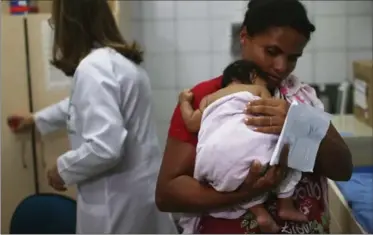  ?? MARIO TAMA, GETTY IMAGES ?? Grandmothe­r Ivalda Caetano carries Ludmilla Hadassa Dias de Vasconcelo­s, two months, who has microcepha­ly.