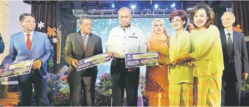  ??  ?? Recipients receiving their presents from Adenan and his wife.