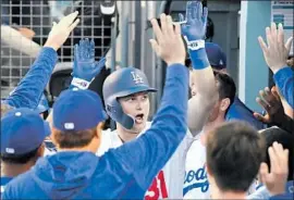  ?? Jayne Kamin-Oncea Getty Images ?? WITH A SHOW of hands, Joc Pederson is greeted in the dugout after his two-run home run in the second inning off Kyle Hendricks gave the Dodgers a 5-2 lead.
