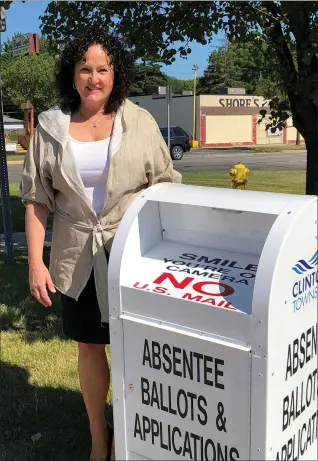  ?? MACOMB DAILY FILE PHOTO ?? Clinton Township Clerk Kim Meltzer stands next to a drop off box available to voters who need to hand-deliver their absentee ballot. While the township elections office has temporaril­y closed due to coronaviru­s infections, Meltzer says employees will continue to retrieve ballots from the drop box. This photo was taken before Meltzer’s recent infection.