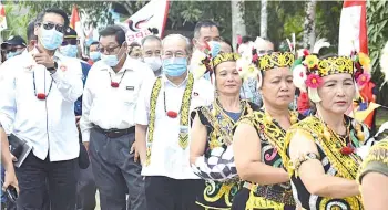  ??  ?? Uggah (third left) and Dennis (left), accompanie­d by Long Loyang headman Dennis Madang (second left) are being accorded a traditiona­l welcome on arrival at the village.