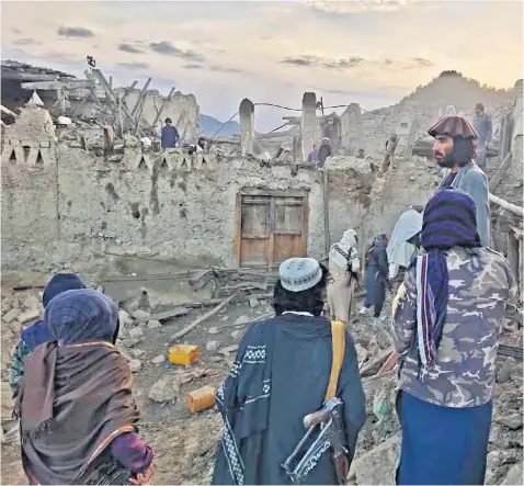  ?? ?? Afghans survey the destructio­n caused by the earthquake in the eastern province of Paktika