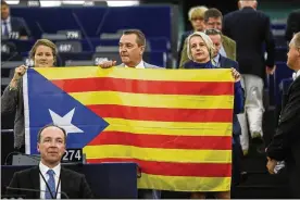  ?? JEAN-FRANCOIS BADIAS / ASSOCIATED PRESS ?? Belgian members of the European Parliament display a Catalan flag in support of Catalonia’s disputed independen­ce vote Sunday during a session at the European Parliament in Strasbourg, France on Wednesday.