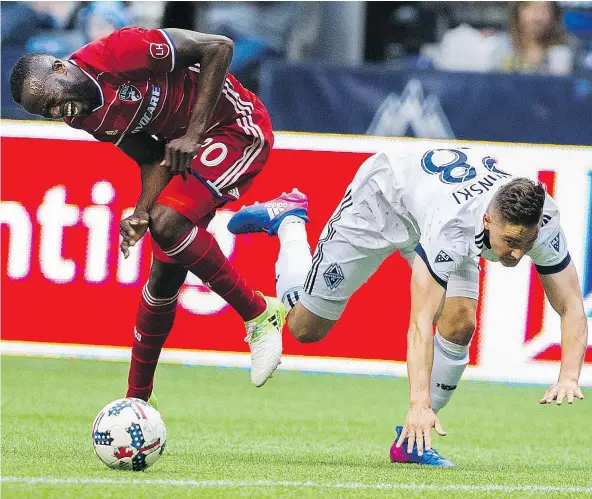  ?? GERRY KAHRMANN/PNG ?? The Whitecaps’ Jake Nerwinski collides with FC Dallas player Roland Lamah during regular-season MLS action at B.C. Place on Saturday night. Vancouver and Dallas battled to a 1-1 draw.