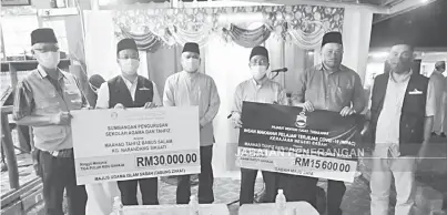  ??  ?? SUMBANGAN: Ariffin (tiga kiri) mewakili Kerajaan Negeri dan MUIS menyampaik­an sumbangan berjumlah RM45,600 kepada Maahad Tahfiz Babus Salam, Kampung Narandang, Sikuati Kudat.