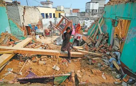  ?? AFP ?? A Pakistani earthquake survivor moves his belongings in the rubble of collapsed houses in an earthquake-hit area on the outskirts of Mirpur in Pakistan.