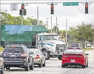  ?? LANNIS WATERS / THE PALM BEACH POST ?? A truck turns left from westbound Belvedere Road onto southbound Sansbury’s Way near the South Florida Fairground­s on Tuesday morning.