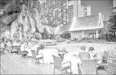  ??  ?? Diners on the patio of a restaurant at the Yalong Bay Mangrove Tree Resort in Sanya.