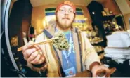  ?? ASSOCIATED PRESS FILE PHOTO ?? Matt Hart holds up a bud of Lemon Skunk, the most potent strain of marijuana available at the 3D Dispensary in Denver on Dec. 9, 2014. A bill making its way through the Colorado Legislatur­e may allow recreation­al pot growers to instantly reclassify...