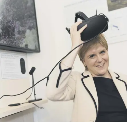  ??  ?? 0 The First Minister tries on a virtual reality set while visiting Tomintoul